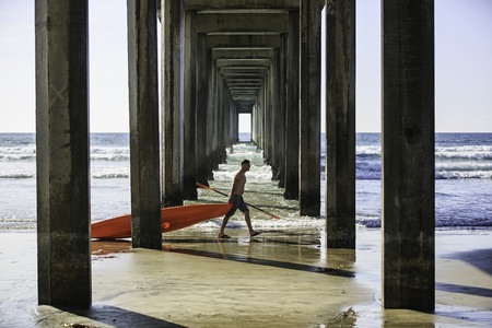 San Diego, California, USA - March 31, 2013  Man dragging a canoe boat walking through the Scripps Pier in La Jolla, San Diego, CA, USA  La Jolla Shore is a popular launch point for kayaking and canoeing のeditorial素材