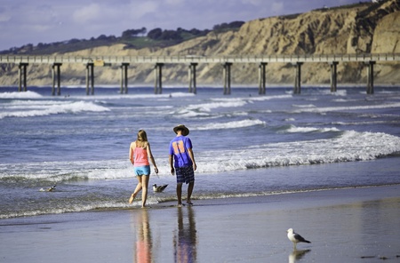 San Diego, California - March 31, 2013  A young couple enjoy walking on La Jolla Shore Beach in San Diego, CA, USA  La Jolla Shore is a very popular vacation place in San Diego, California のeditorial素材