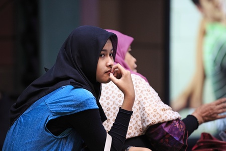 Genting Hinglands, Malaysia - June 20, 2013  Malaysian girl wearing tudung scarf headscarf  sitting in Resorts World Genting, Malaysia  The tudung scarf is very commonly worn by Malay girls and women のeditorial素材