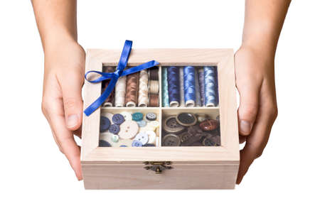 Pretty female hands show wooden sewing boxの写真素材