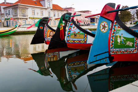 View of handmade paints in traditional moliceiro boats, in a canal of Aveiro, Portugalのeditorial素材