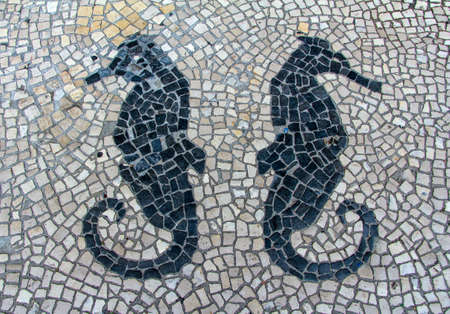 Clear stone blocks pavement texture with a dark central sea horses motive for backgroundの写真素材