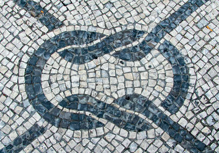 Clear stone blocks pavement texture with a dark central marine knot motive for backgroundの写真素材