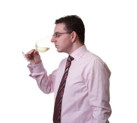 Portrait of a man with tie smelling a glass of white wineの写真素材