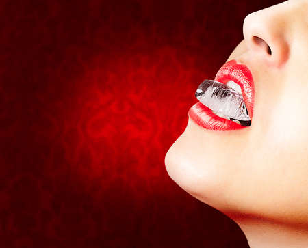 Closeup of sensual lips with red lipstick and an ice cubeの写真素材
