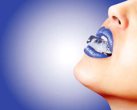 Closeup of sensual lips with blue lipstick and an ice cubeの写真素材
