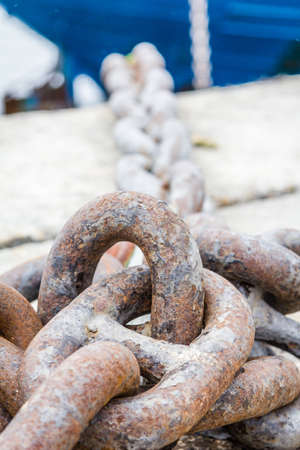 Closeup of ship anchor chain moored in the dockの写真素材