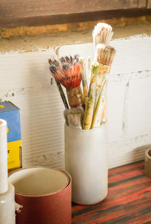 Set of paint brushes on jar, in a artistic red tableの写真素材