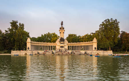 Buen Retiro park lake in Madrid with monument to Alfonso XII on the background