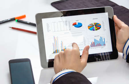 Businesswoman showing financial charts and documents in a digital tablet