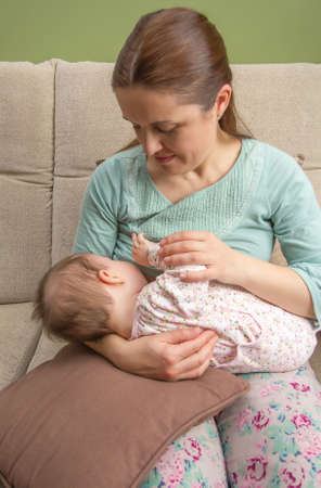 Young mother breast feeding her baby at home in a relaxed atmosphere