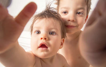 Portrait of sweet boy and little girl with wet hair taking a selfie photo after the bath  Image focused on boy の写真素材