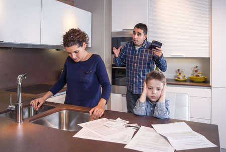 Sad son and worried mother suffering while furious father scream in a home kitchen by economic difficulties  Family problems concept の写真素材