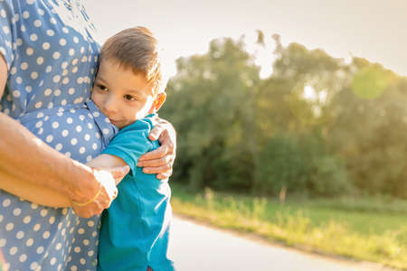 Portrait of happy grandson hugging grandmother over a nature outdoor backgroundの写真素材