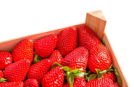 Corner of wooden box of tasty spanish strawberries freshly collected isolated on white backgroundの写真素材