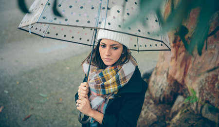 Portrait of young beautiful girl under a umbrella in an autumn rainy dayの写真素材