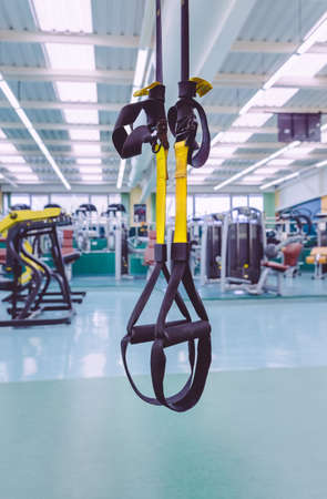 Closeup of fitness straps ready to use in a fitness center. Suspension training concept.の写真素材