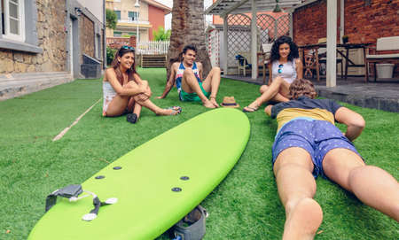 Group of young people having fun in a summer surf class outdoors. Holidays leisure concept.の写真素材