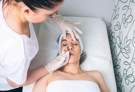 Young pretty woman getting cosmetic injection in the face like a part of the clinic treatment....