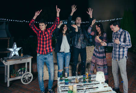 Group of happy young friends dancing and having fun with the music in a outdoors party. Friendship and celebrations concept.の写真素材