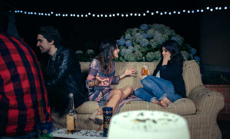 Beautiful young woman talking about her problems to bored female friend in a outdoors party. Friendship and celebrations concept.の写真素材