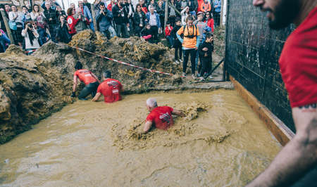 GIJON, SPAIN - JANUARY 31, 2016: Runners into the Farinato Race event, a extreme obstacle race,...