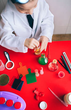 View from above of little boy scientist mixing yellow liquid in a bottleの写真素材