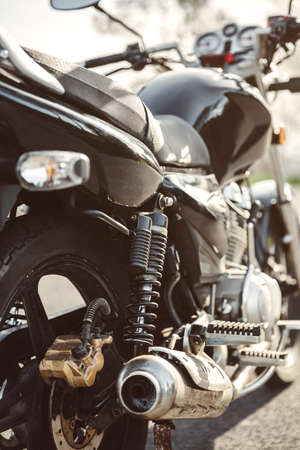 Close up shock absorber, exhaust pipe and disk brake of black shiny motorcycleの写真素材
