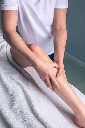 Close up of female therapist hands doing lymphatic drainage massage on legs of woman in a clinical center. Medicine, healthcare and beauty concept.の写真素材