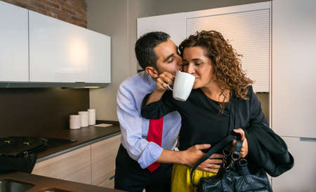 Happy businessman embracing and kissing woman at breakfastの写真素材