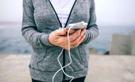 Closeup of senior sportswoman holding her smartphoneの写真素材