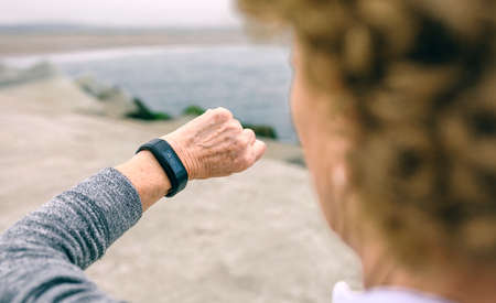 Unrecognizable senior woman looking smart watchの写真素材