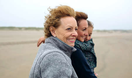 Closeup of three generations female walking on the beach in autumnの写真素材