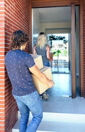 Moving couple carrying boxes to their new homeの写真素材