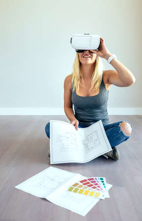 Young woman watching the decoration of her house with virtual reality glasses
