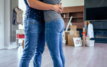 Couple hugging in the living room of their new houseの写真素材