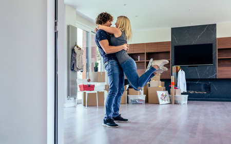 Couple hugging in the living room of their new house