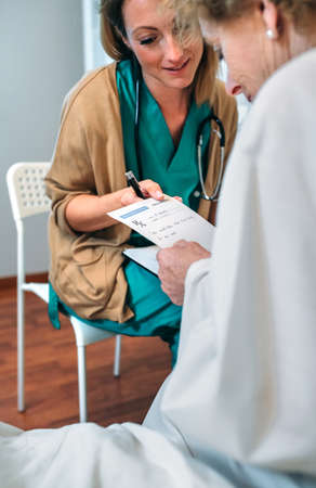 Female doctor giving a prescription to female senior patientの写真素材