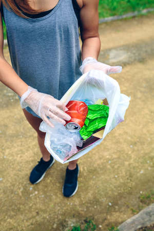 Plogging concept. Detail of girl showing garbage bag