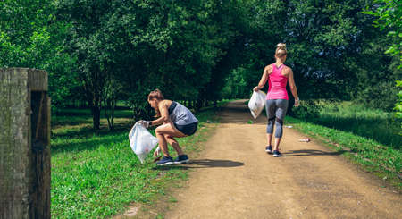Two girls on back with garbage bags doing ploggingの写真素材