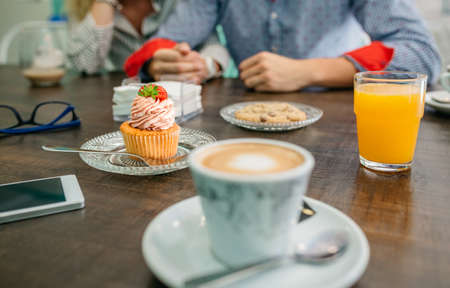 Breakfast in a pastry shop with couple holding hands in backgroundの写真素材