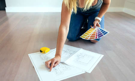 Young woman looking house plans on the floorの写真素材