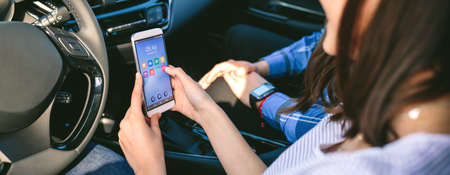 Girl with her boyfriend using the cell phone in the car
