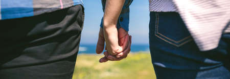 Detail of young unrecognizable couple holding hands outdoorsの写真素材