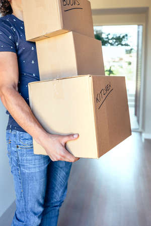 Young man carrying moving cardboard boxes