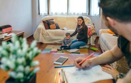 Young man coloring mandalas in the living room