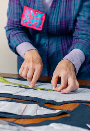 Woman dressmaker design tailor pattern for a suit on the table