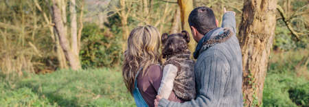Back view of couple with her little daughter enjoying together of the forest landscape. Family leisure time concept.の写真素材