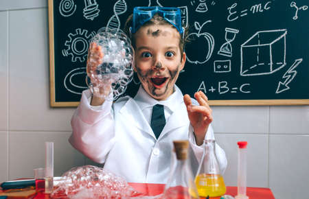 Funny happy boy dressed as chemist with dirty face after doing an experimentの写真素材