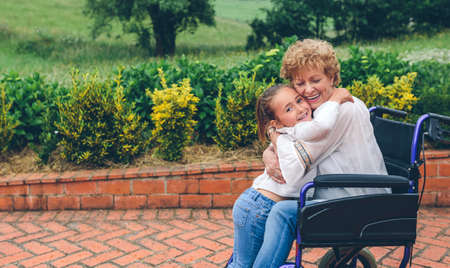 Granddaughter hugging her grandmother in a wheelchair